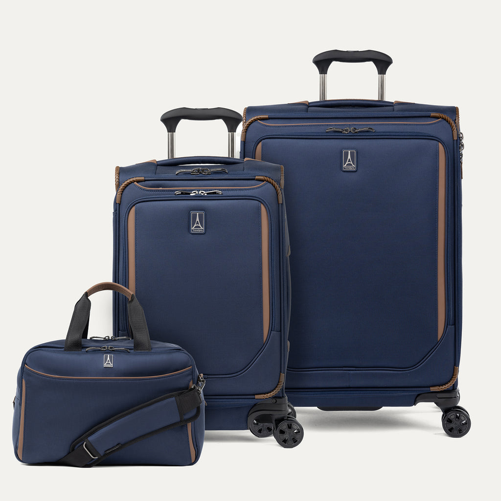 Set of three navy blue suitcases with brown accents on a light gray background