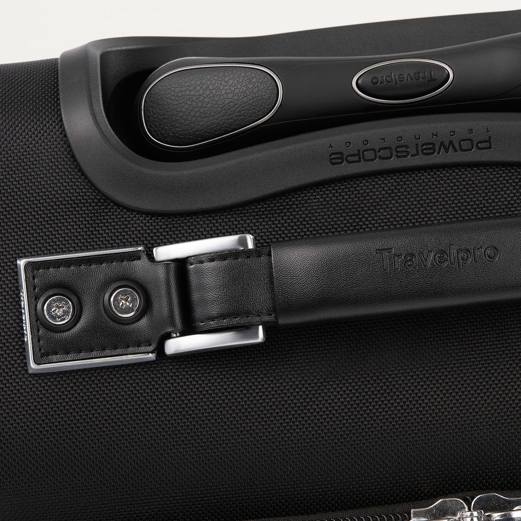 Close-up of a black suitcase handle with visible branding.