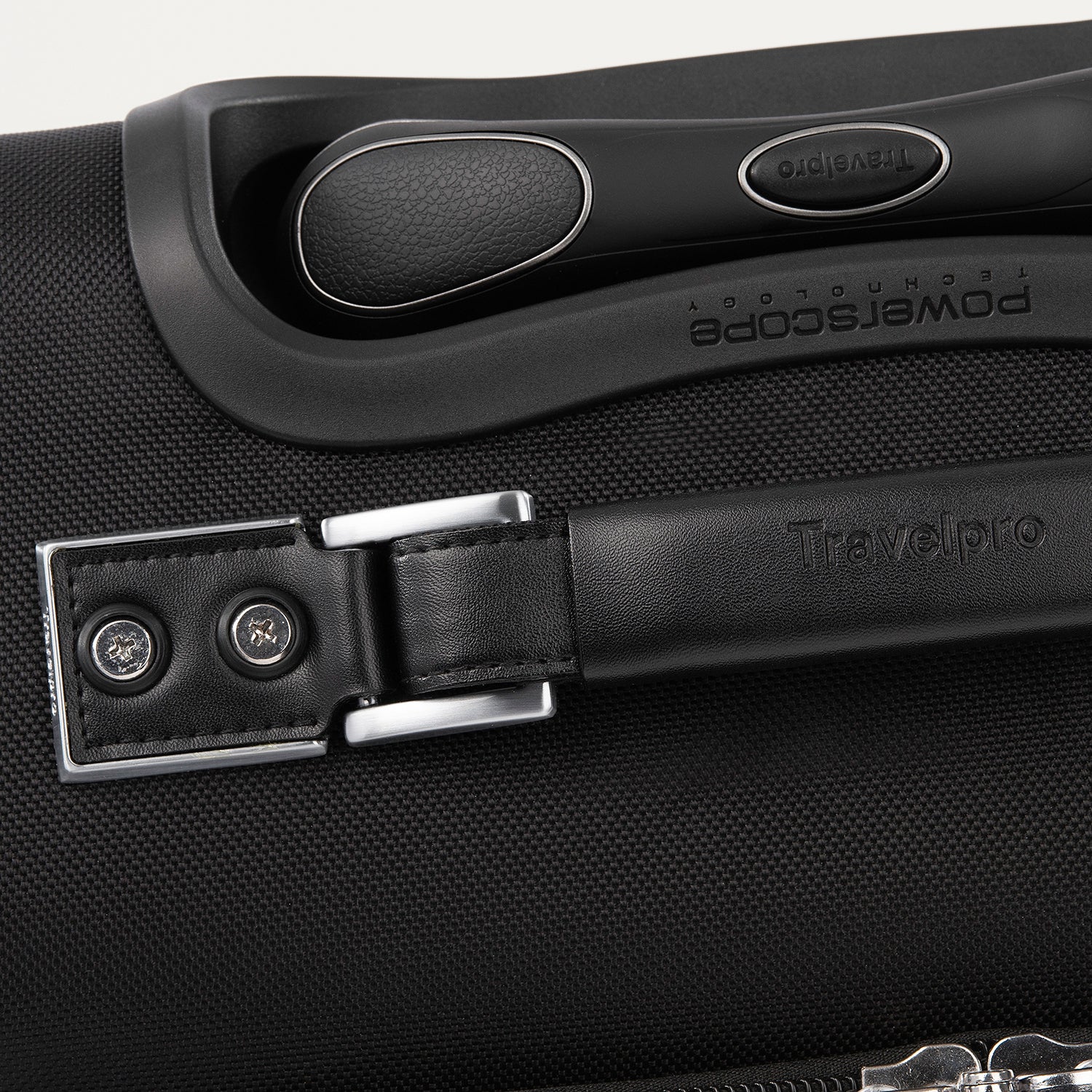 Close-up of a black suitcase handle with visible branding.