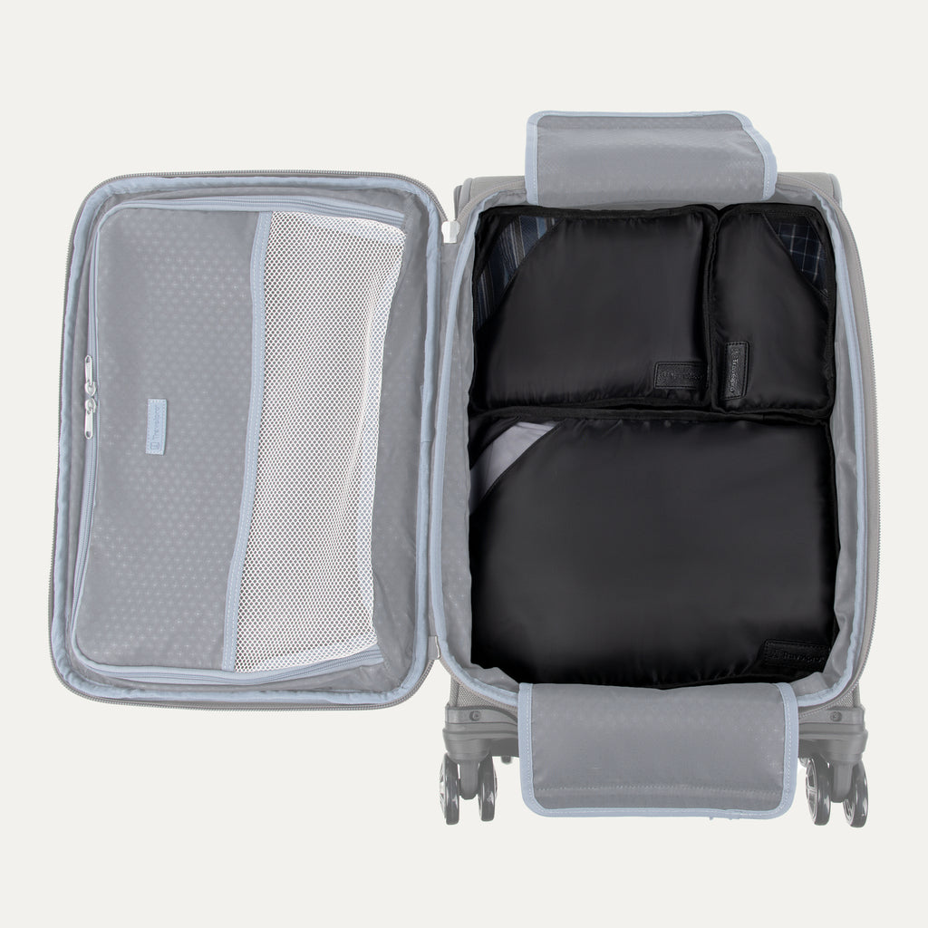 Gray suitcase with open compartment showing black packing cubes and mesh pocket on a light gray background