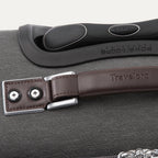 Close-up of a suitcase handle and latch on a gray suitcase.