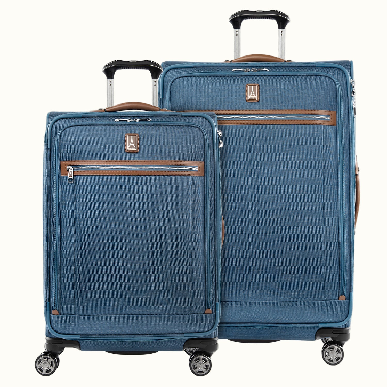 A set of two blue suitcases with spinner wheels and brown accents on a white background