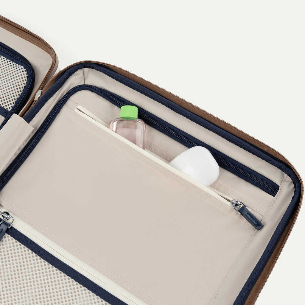 Open travel case with toiletries on a white background