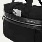 Black tote with a phone in the QuickSlip® front pocket compartment on a white background 