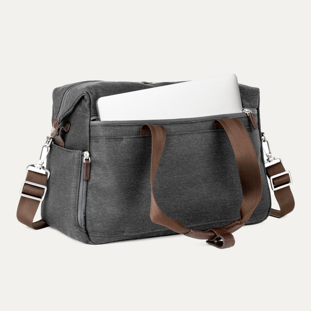 Vintage grey tote with a laptop in the padded sleeve compartment on a white background 