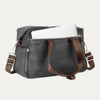 Vintage grey tote with a laptop in the padded sleeve compartment on a white background 