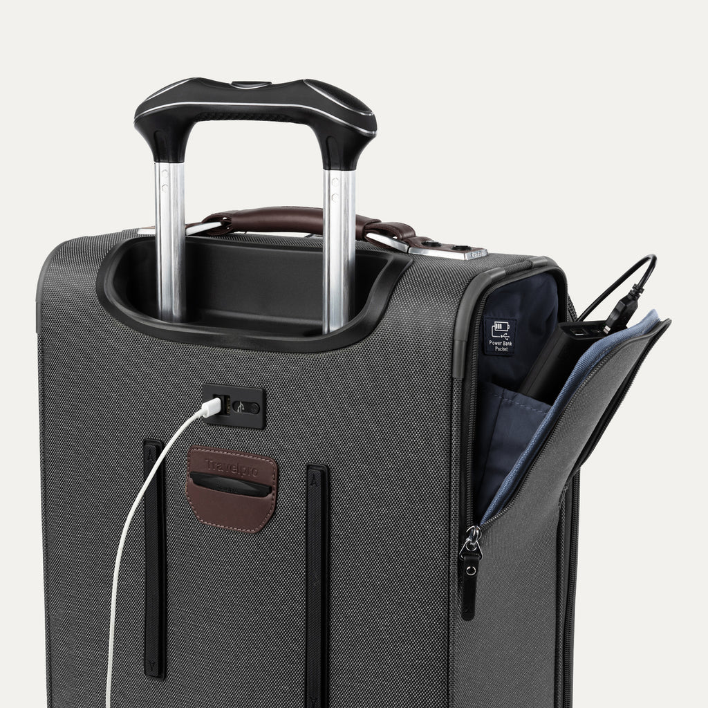 Close-up of grey suitcase with extended handle and visible USB charging cable, on white background