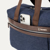 True navy tote with a phone in the QuickSlip® front pocket  compartment on a white background 