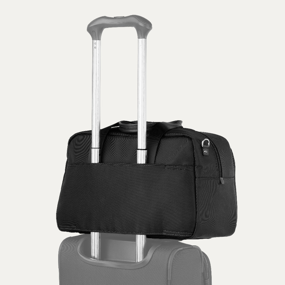 black tote on top of a carry on suitcase
