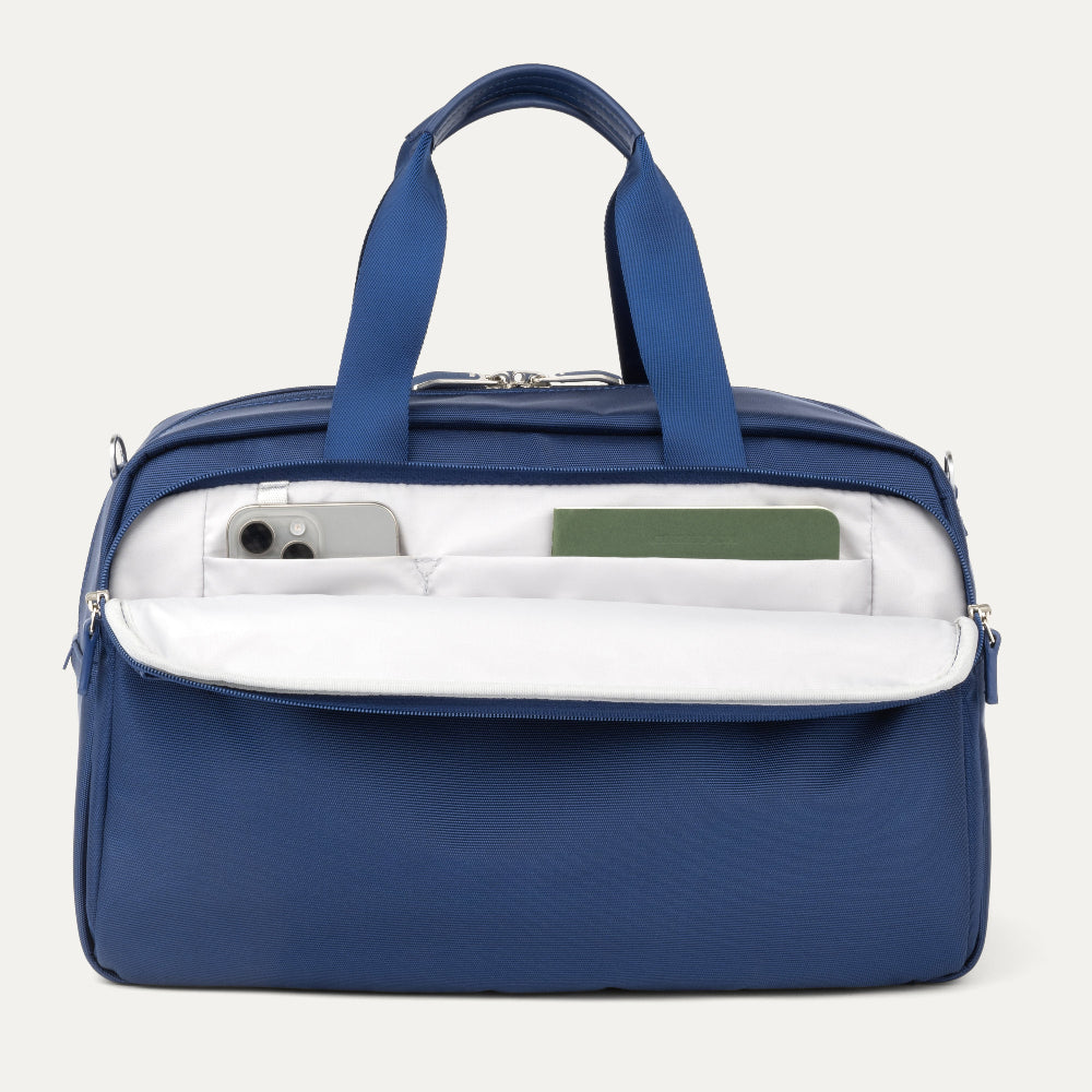Blue tote bag with interior compartments on a light gray background