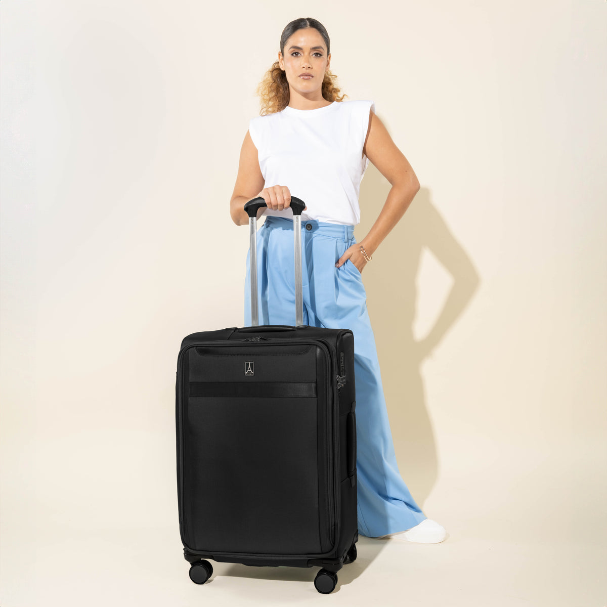 Person holding a black check in suitcase on a white background