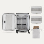 Open suitcase with packing accessories on a white background