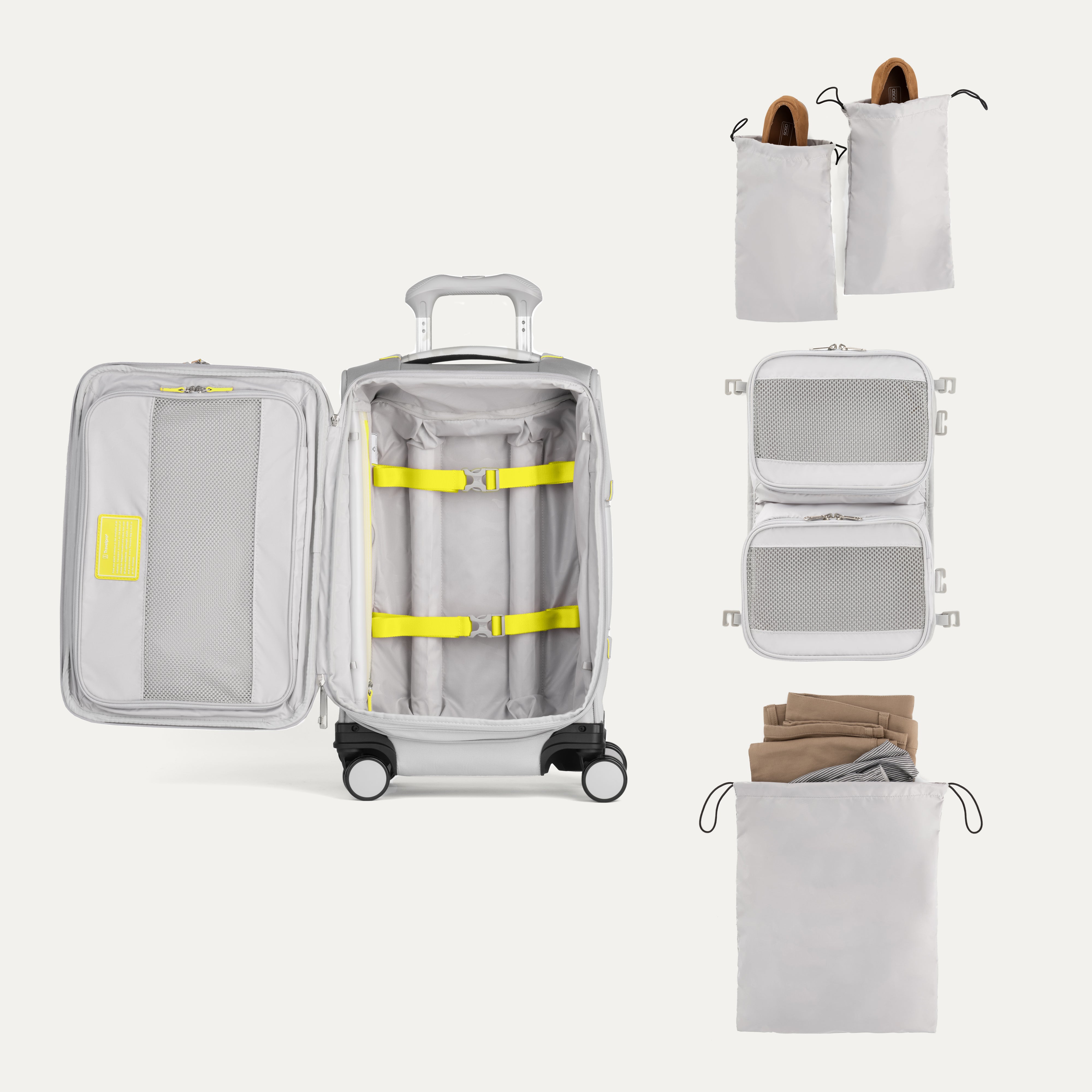 Set of travel packing cubes, shoebags and a suitcase with yellow straps on a white background