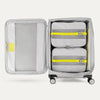 Open suitcase with packing cubes inside on a white background