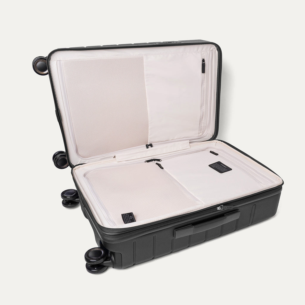 Open interior of the Medium Check-In from the Travelpro Platinum Reserve Compact Carry-On / Medium Check-In Hardside Set in Black Dust showing the zippered divider panel