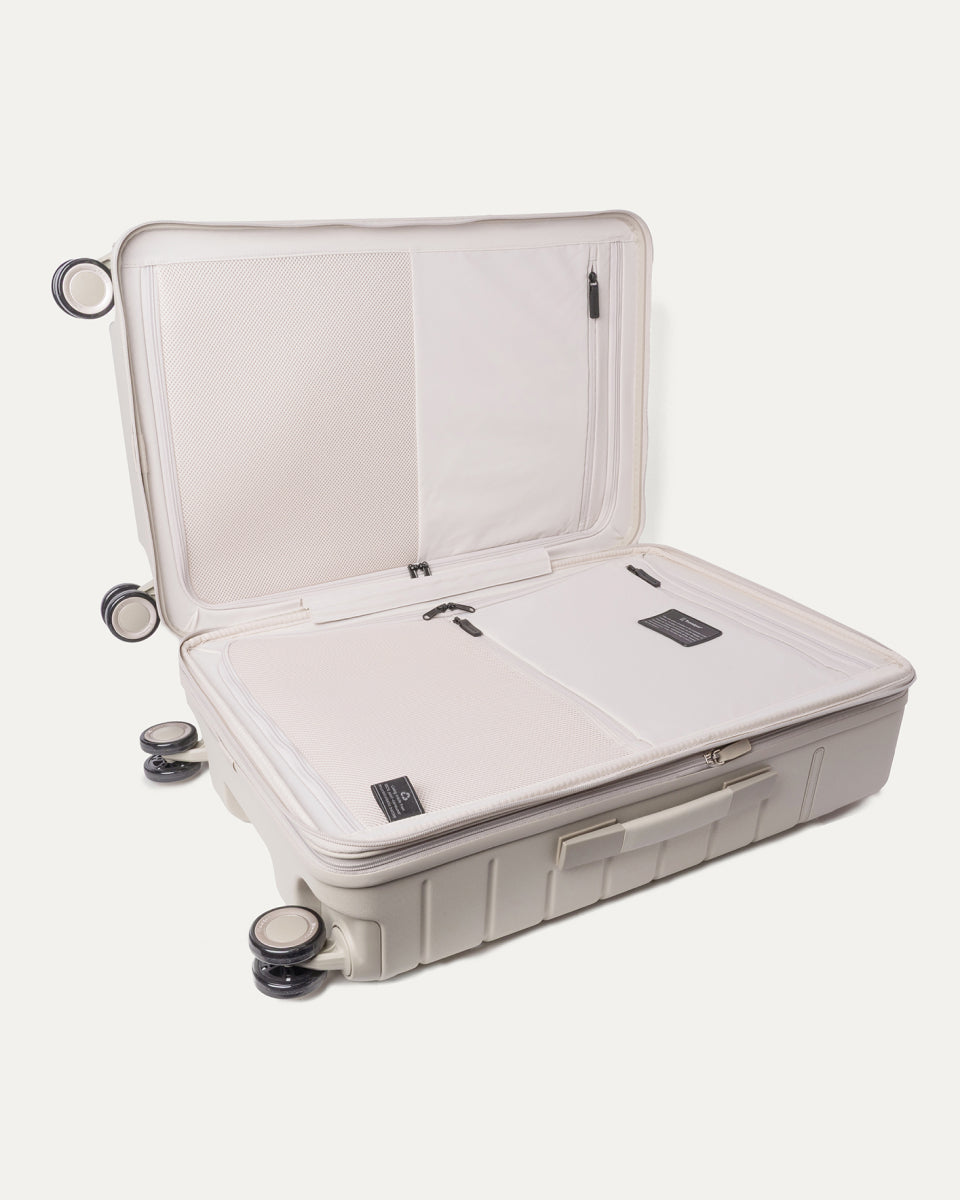Open interior of the Medium Check-In from the Travelpro Platinum Reserve Compact Carry-On / Medium Check-In Hardside Set in Sandstone showing the zippered divider panel