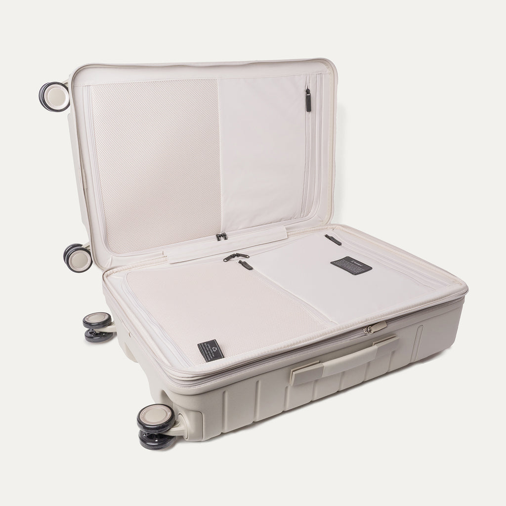 Open interior of the Medium Check-In from the Travelpro Platinum Reserve Compact Carry-On / Medium Check-In Hardside Set in Sandstone showing the zippered divider panel