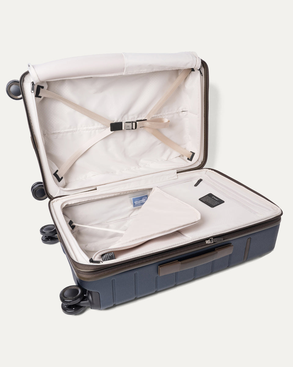 Open interior of the Medium Check-In from the Travelpro Platinum Reserve Compact Carry-On / Medium Check-In Hardside Set in Midnight Trail with hold-down straps