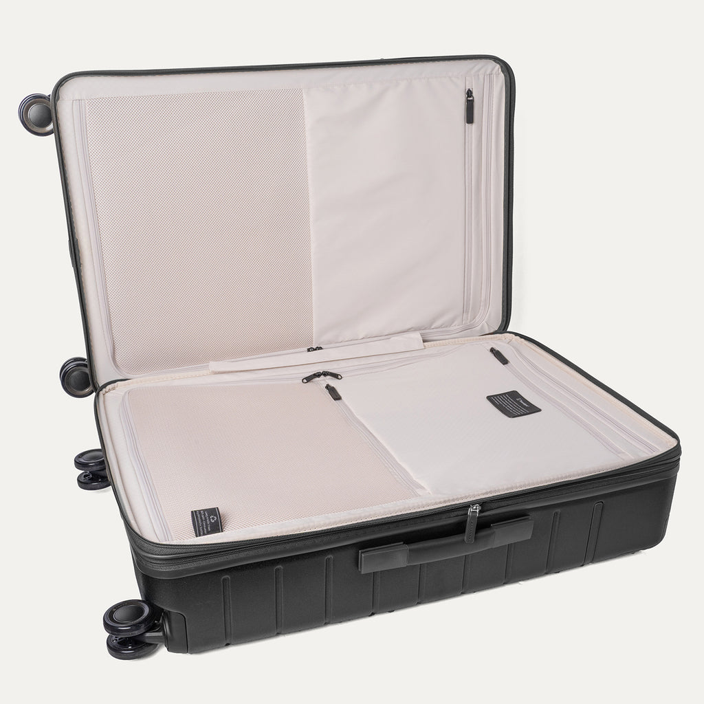 Open interior of the Large Check-In from the Travelpro Platinum Reserve Carry-On / Medium / Large Hardside Set in Black Dust showing the zippered divider panel