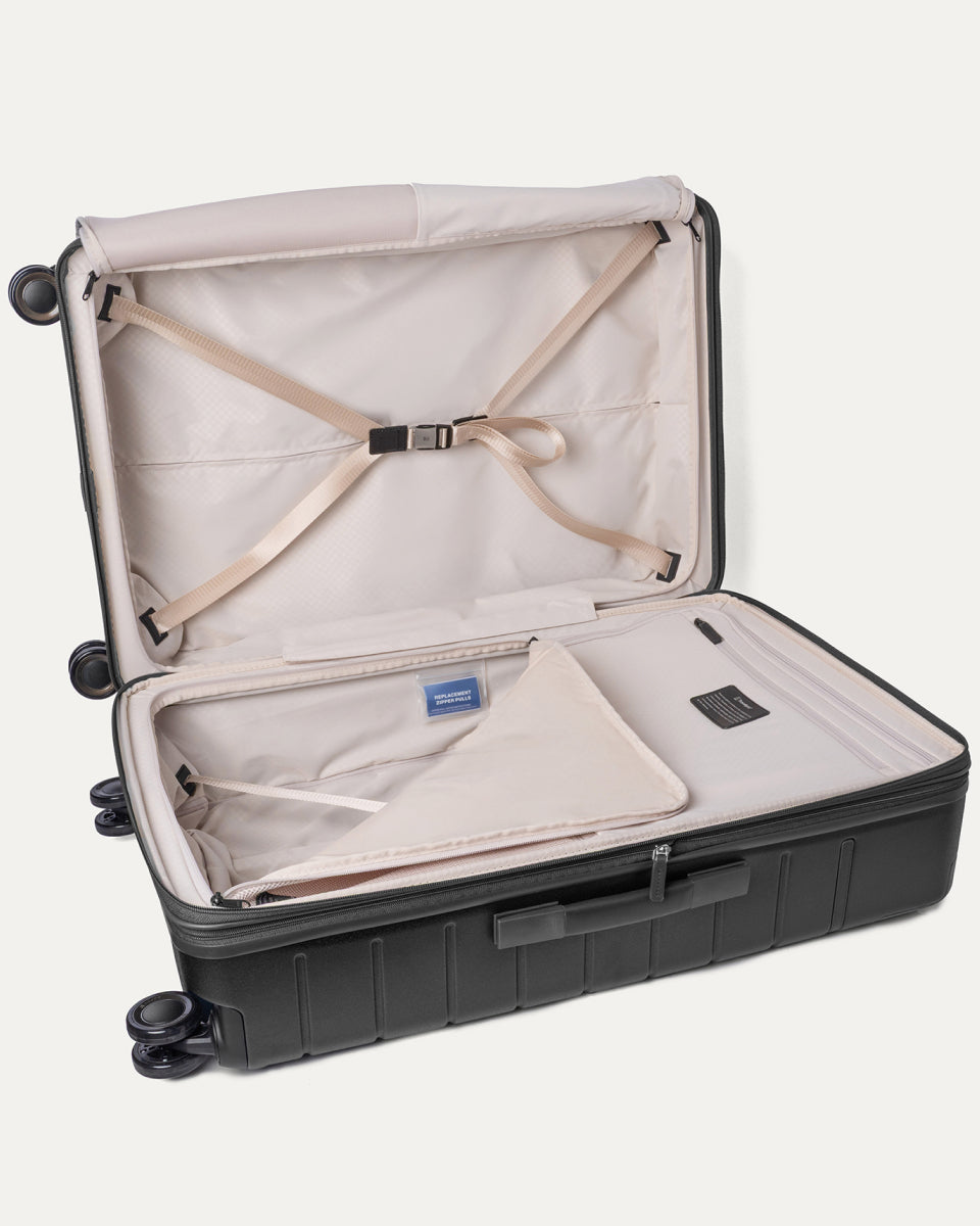 Open interior of the Large Check-In from the Travelpro Platinum Reserve Carry-On / Large Check-In Hardside Set in Black Dust with hold-down straps