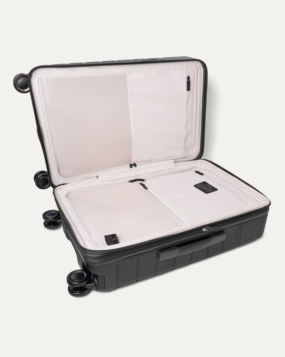 Open interior of the Medium Check-In from the Travelpro Platinum Reserve Carry-On / Medium Check-In Hardside Set in Black Dust showing the zippered divider panel