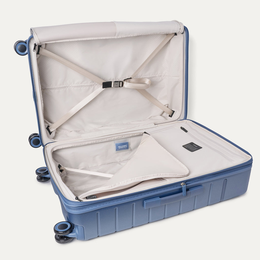Open interior of the Large Check-In from the Travelpro Platinum Reserve Carry-On / Medium / Large Hardside Set in Steel Blue with hold-down straps