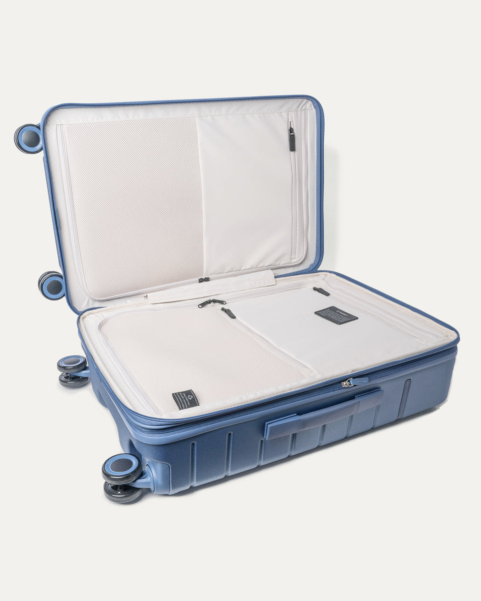 Open interior of the Medium Check-In from the Travelpro Platinum Reserve Carry-On / Medium / Large Hardside Set in Steel Blue showing the zippered divider panel