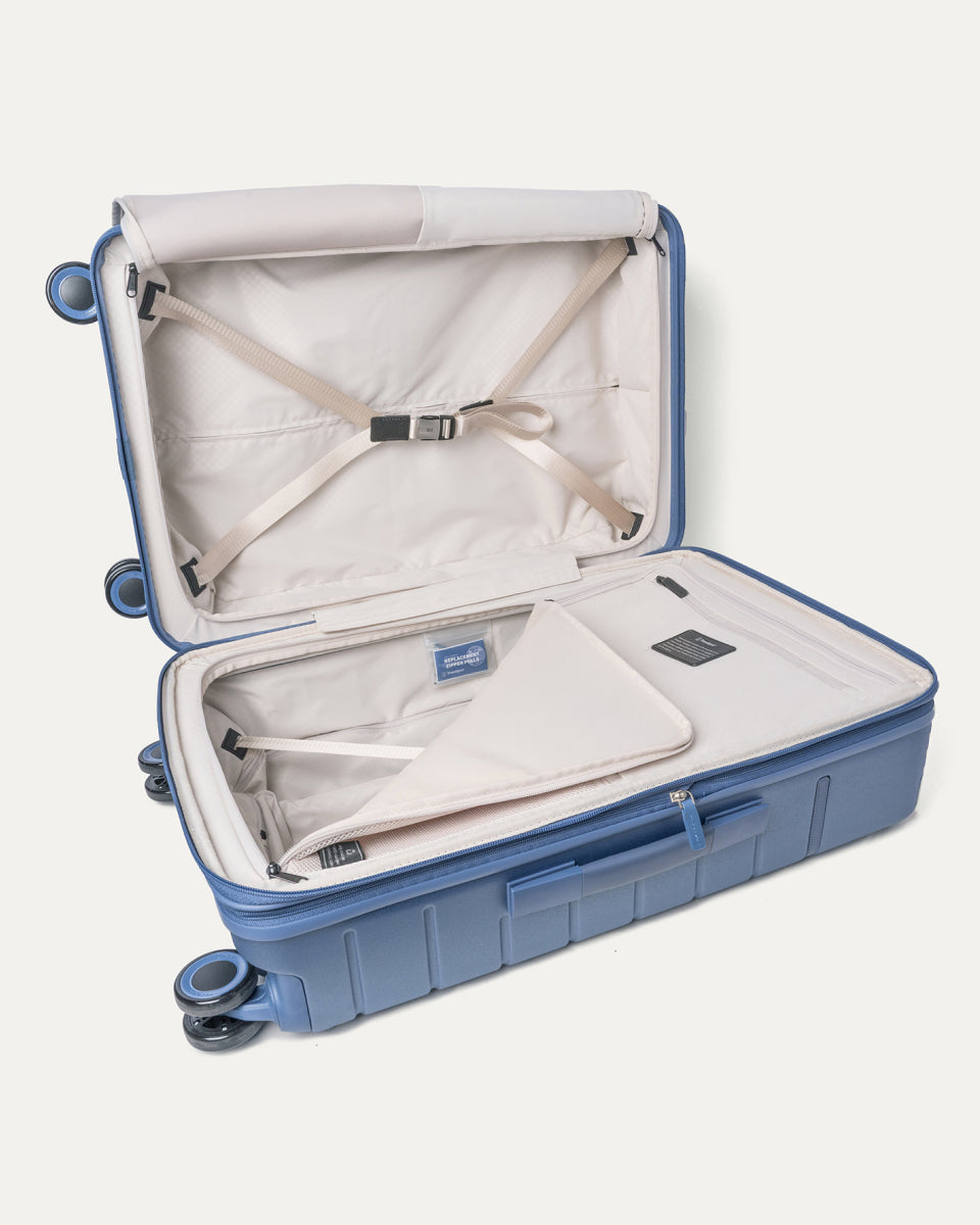 Open interior of the Medium Check-In from the Travelpro Platinum Reserve Carry-On / Medium / Large Hardside Set in Steel Blue with hold-down straps