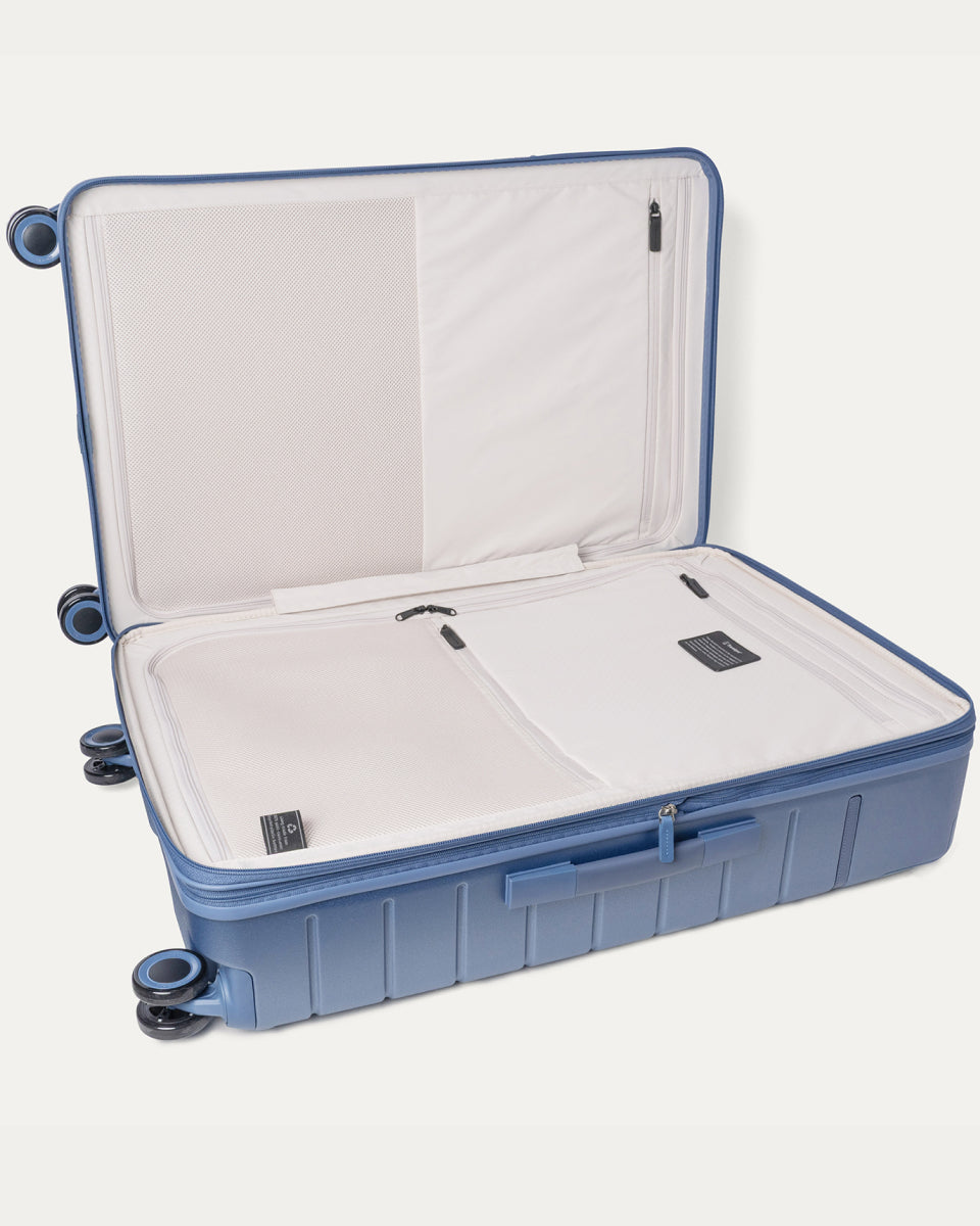 Open interior of the Large Check-In from the Travelpro Platinum Reserve Carry-On / Medium / Large Hardside Set in Steel Blue showing the zippered divider panel