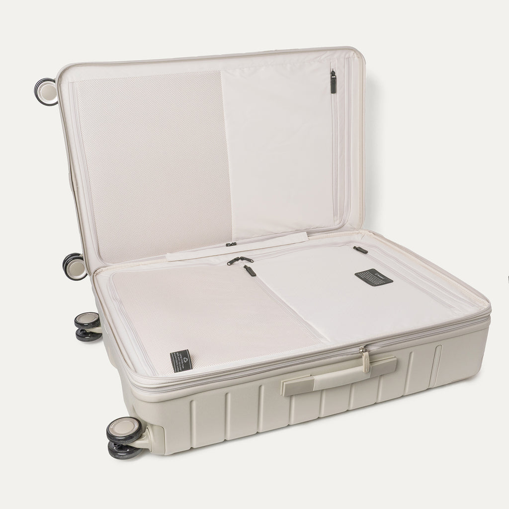 Open interior of the Large Check-In from the Travelpro Platinum Reserve Carry-On / Medium / Large Hardside Set in Sandstone showing the zippered divider panel