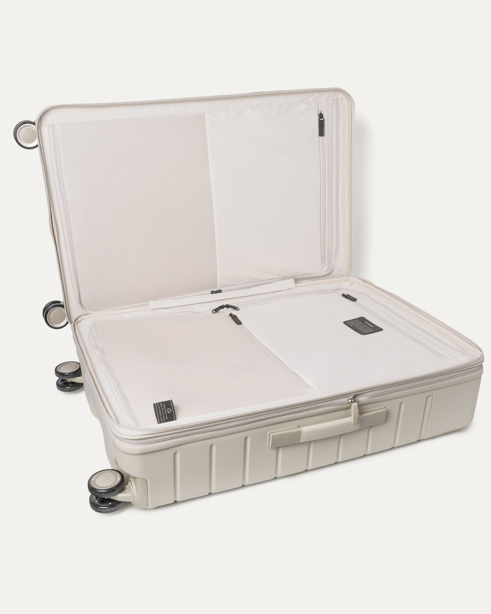 Open interior of the Large Check-In from the Travelpro Platinum Reserve Carry-On / Medium / Large Hardside Set in Sandstone showing the zippered divider panel