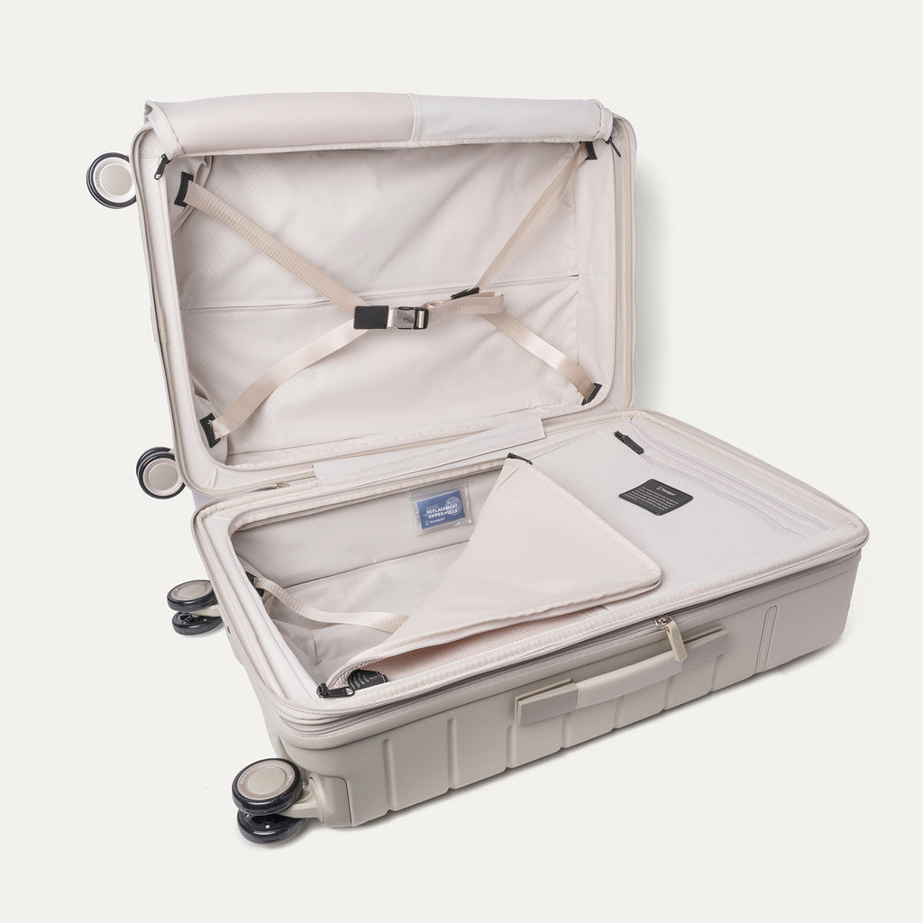 Open interior of the Medium Check-In from the Travelpro Platinum Reserve Carry-On / Medium / Large Hardside Set in Sandstone with hold-down straps