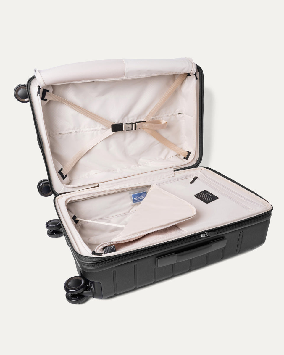 Open interior of the Medium Check-In from the Travelpro Platinum Reserve Medium / Large Check-In Hardside Set in Black Dust with hold-down straps