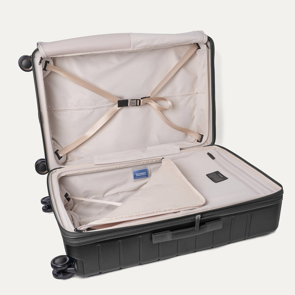 Open interior of the Large Check-In from the Travelpro Platinum Reserve Medium / Large Check-In Hardside Set in Black Dust with hold-down straps