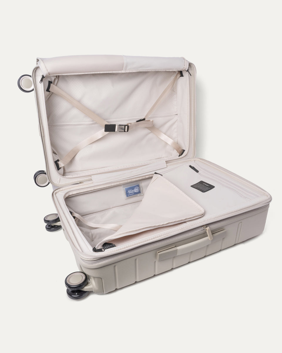 Open interior of the Medium Check-In from the Travelpro Platinum Reserve Medium / Large Check-In Hardside Set in Sandstone with hold-down straps