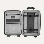 Interior view of the open Optima Expandable Compact Carry-On in Black, showcasing the spacious split-case organization with zippered mesh divider panels, compression straps, and interior accessory pockets.