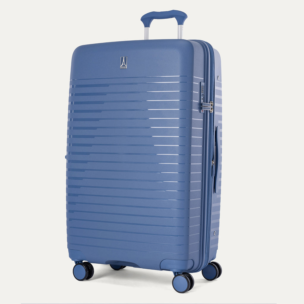 Three-quarter view of the Optima Expandable Large Check-In hardside spinner in Horizon Blue, showcasing the durable textured exterior, telescoping handle, and multi-directional spinner wheels.