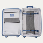 Interior view of the open Optima Expandable Medium Check-In suitcase in Horizon Blue, showcasing the spacious split-case design with zippered mesh divider panels, compression straps, and interior accessory pockets.