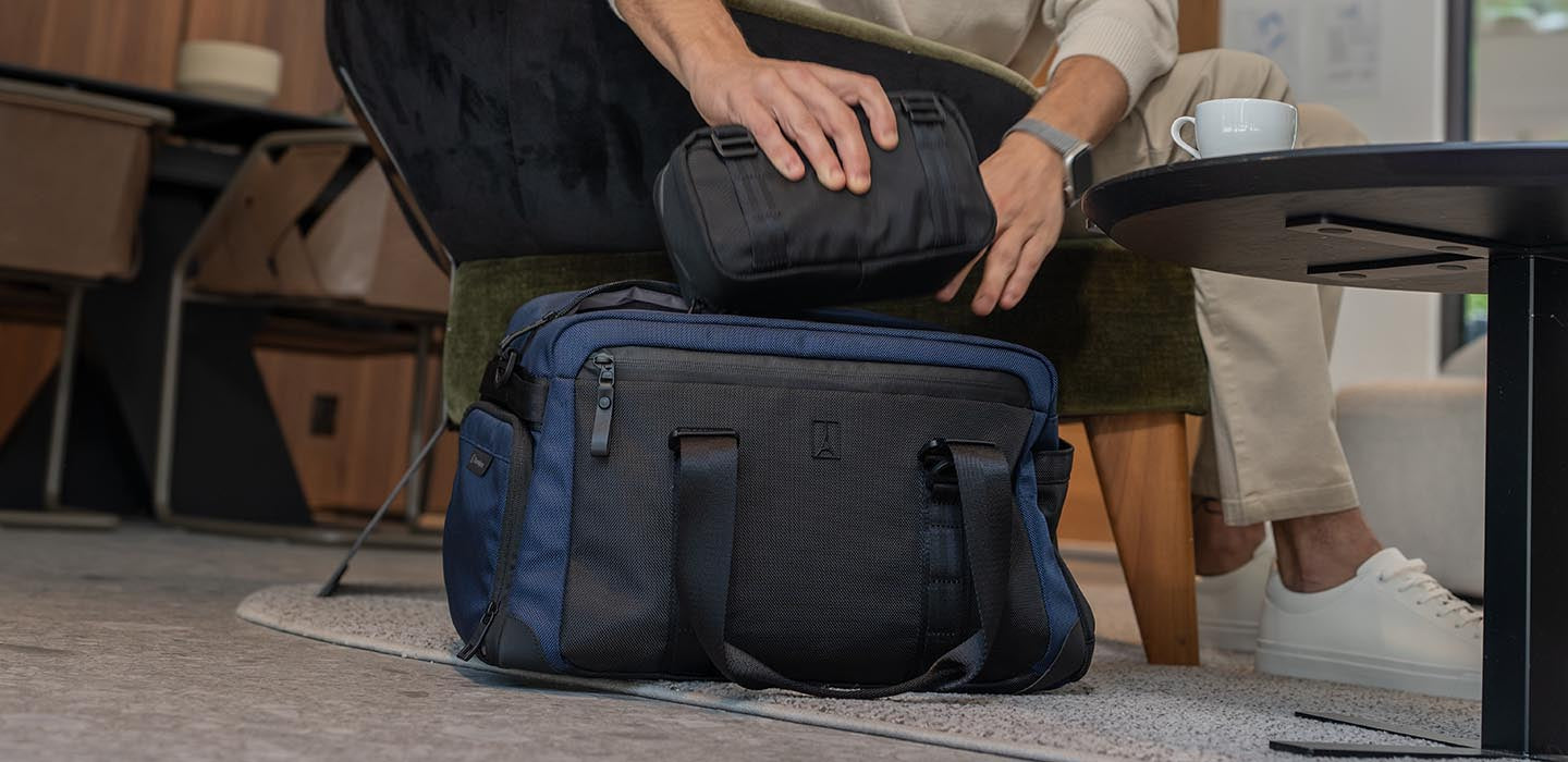 Person organizing items in a blue duffel bag on a chair