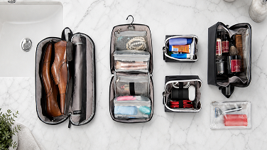 Travel accessories: toiletry kits, a shoe bag, and packing pouches on a marble counter