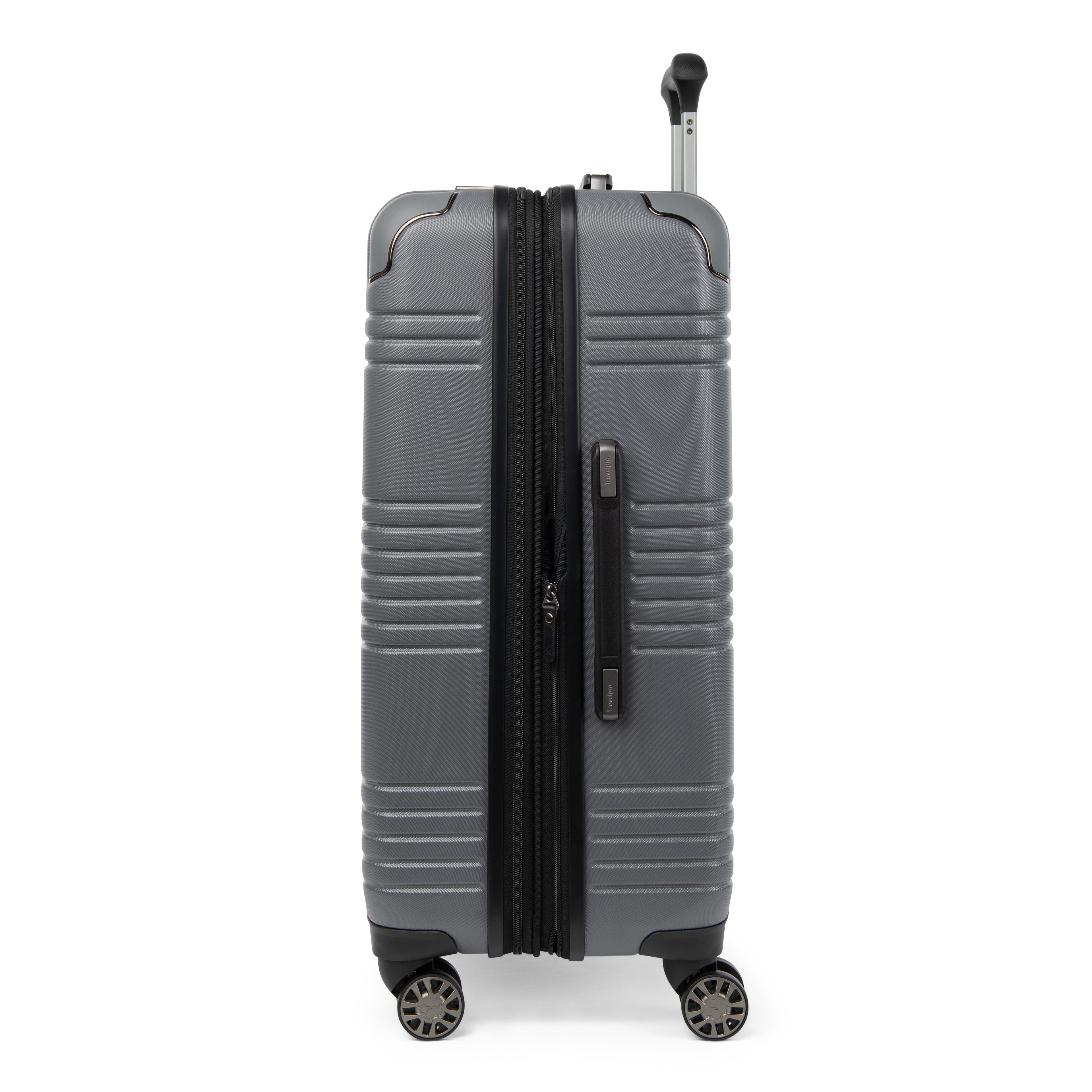 Side profile view of the Travelpro Roundtrip Hardshell Medium Check-In Suitcase in Gunmetal Gray, showing textured hardshell design, expansion zipper open, black telescoping handle, and four spinner wheels against white background.