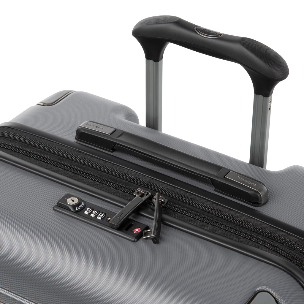 Close-up of a Gunmetal grey hard-shell suitcase with an extended black telescoping handle, top carry handle, zipper, and combination lock on a white background.