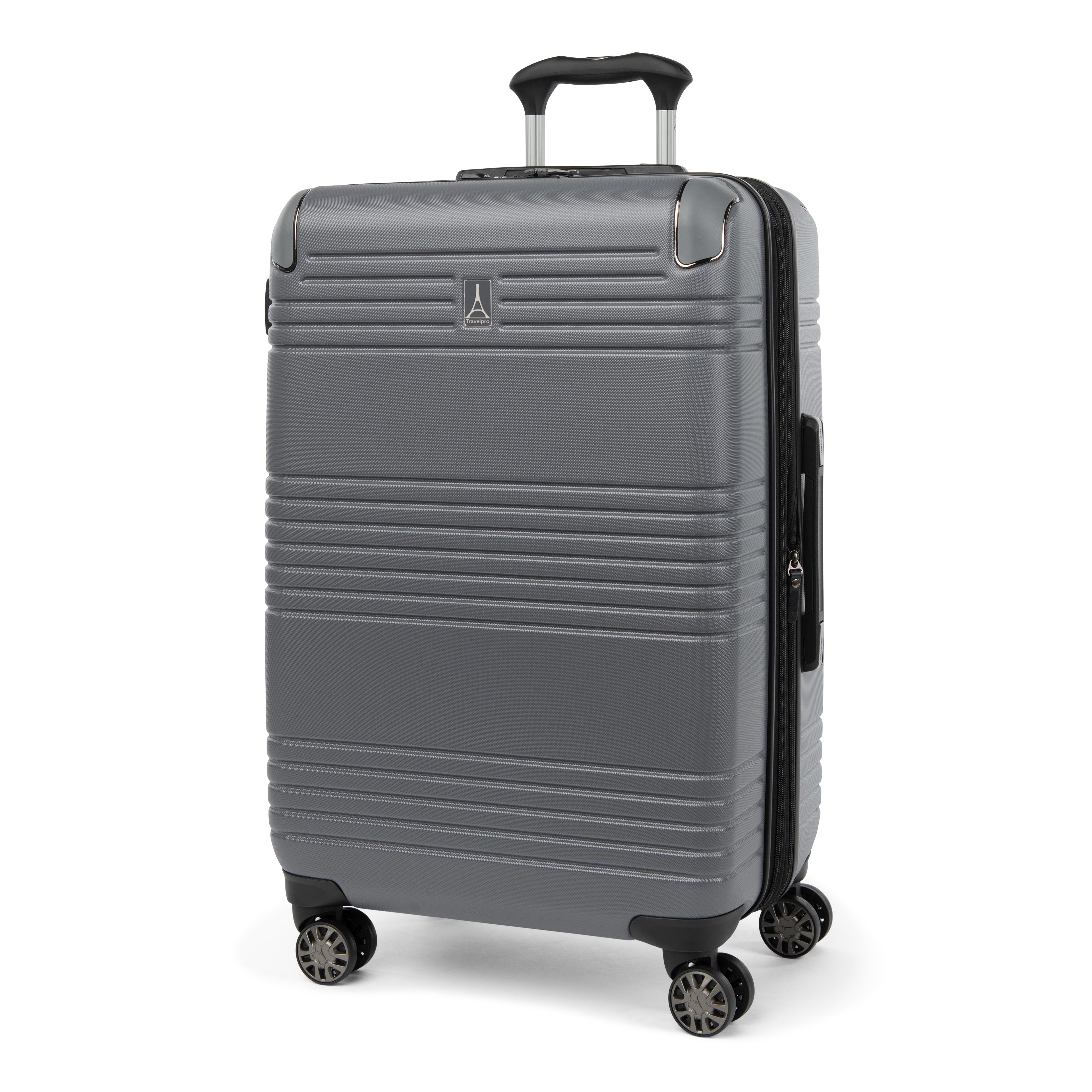 Three-quarter front view of the Travelpro Roundtrip Medium Check-In Expandable Spinner in Gunmetal Gray, showing textured hardshell design with horizontal ridges, a small metallic logo on the front, and four multi-directional wheels against a clean white background.
