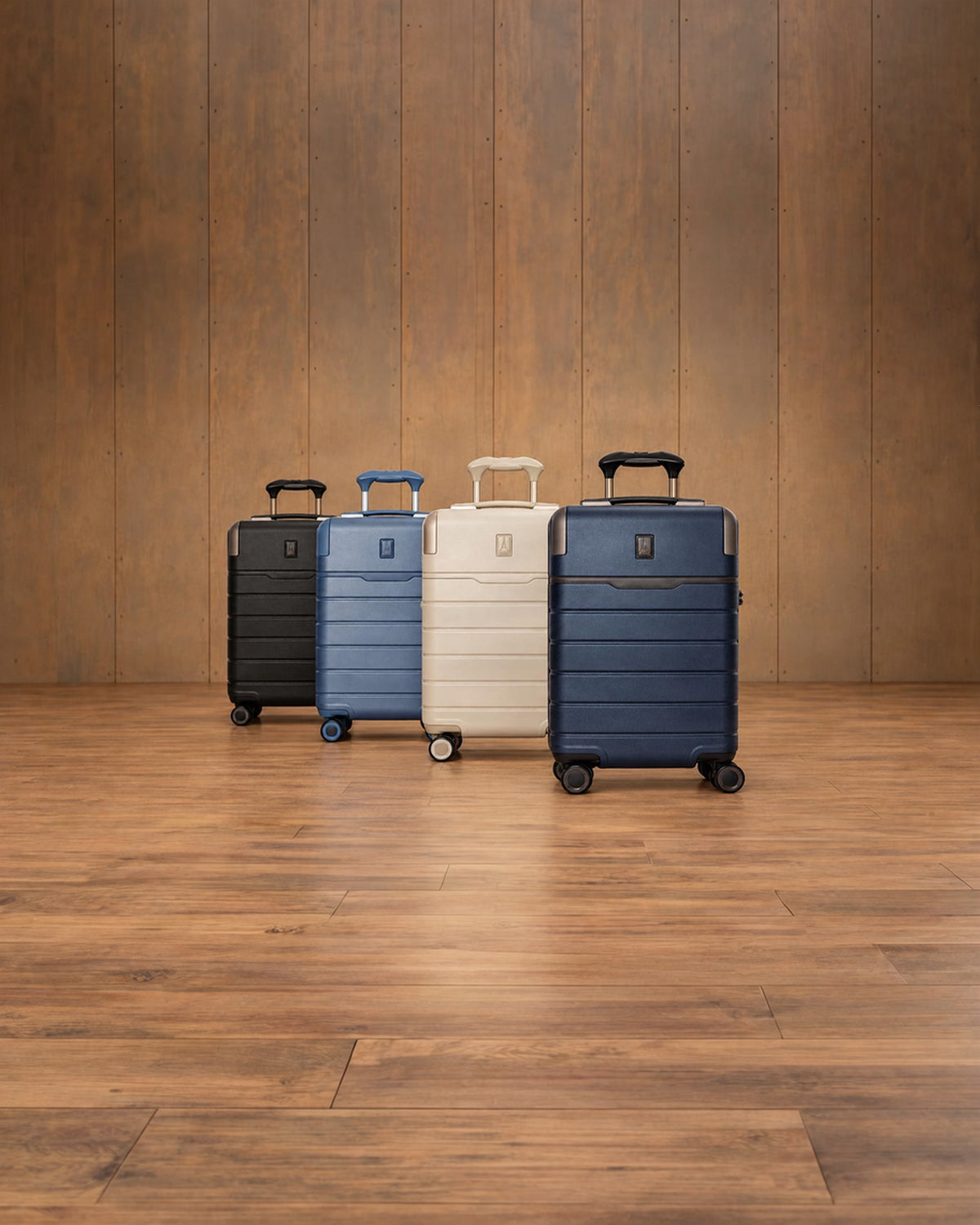 Platinum Reserve carry-ons in Black Dust, Steel Blue, Sandstone and Midnight Trail on a wood floor