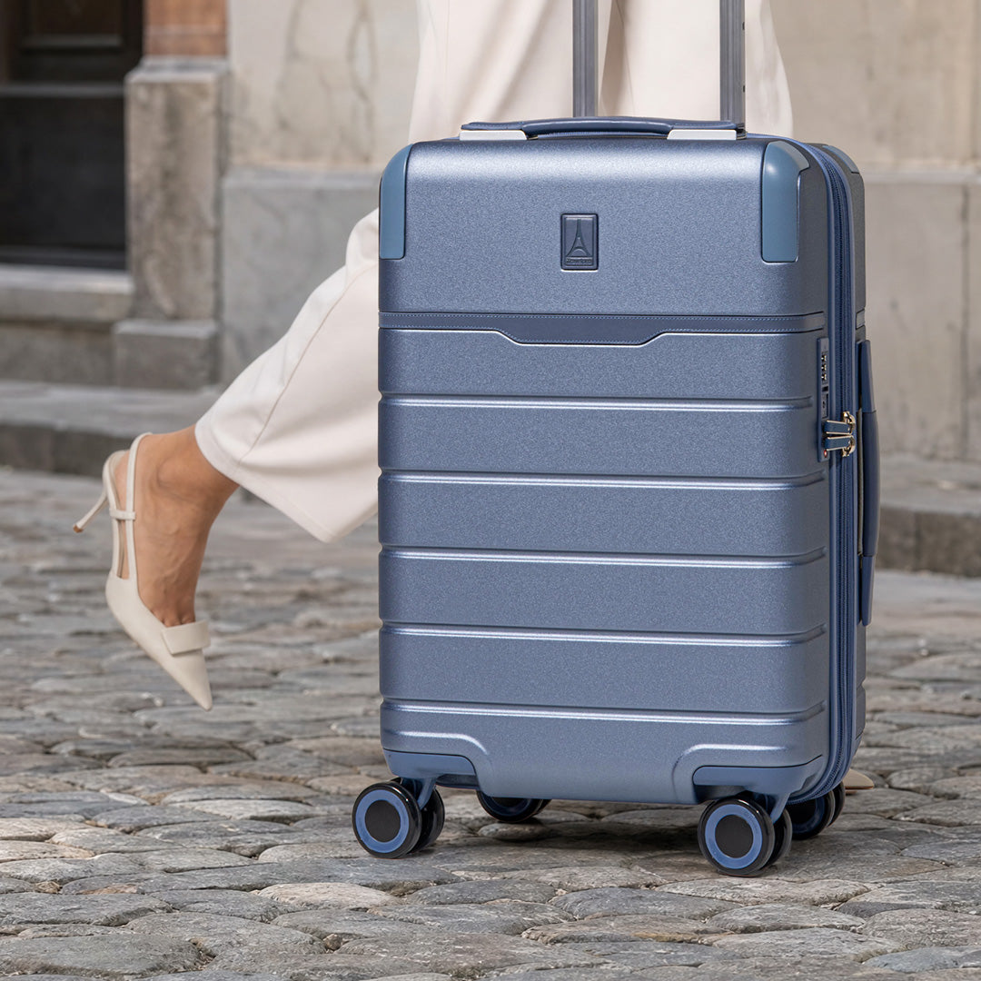Steel Blue Platinum Reserve carry-on rolling on a cobblestone street
