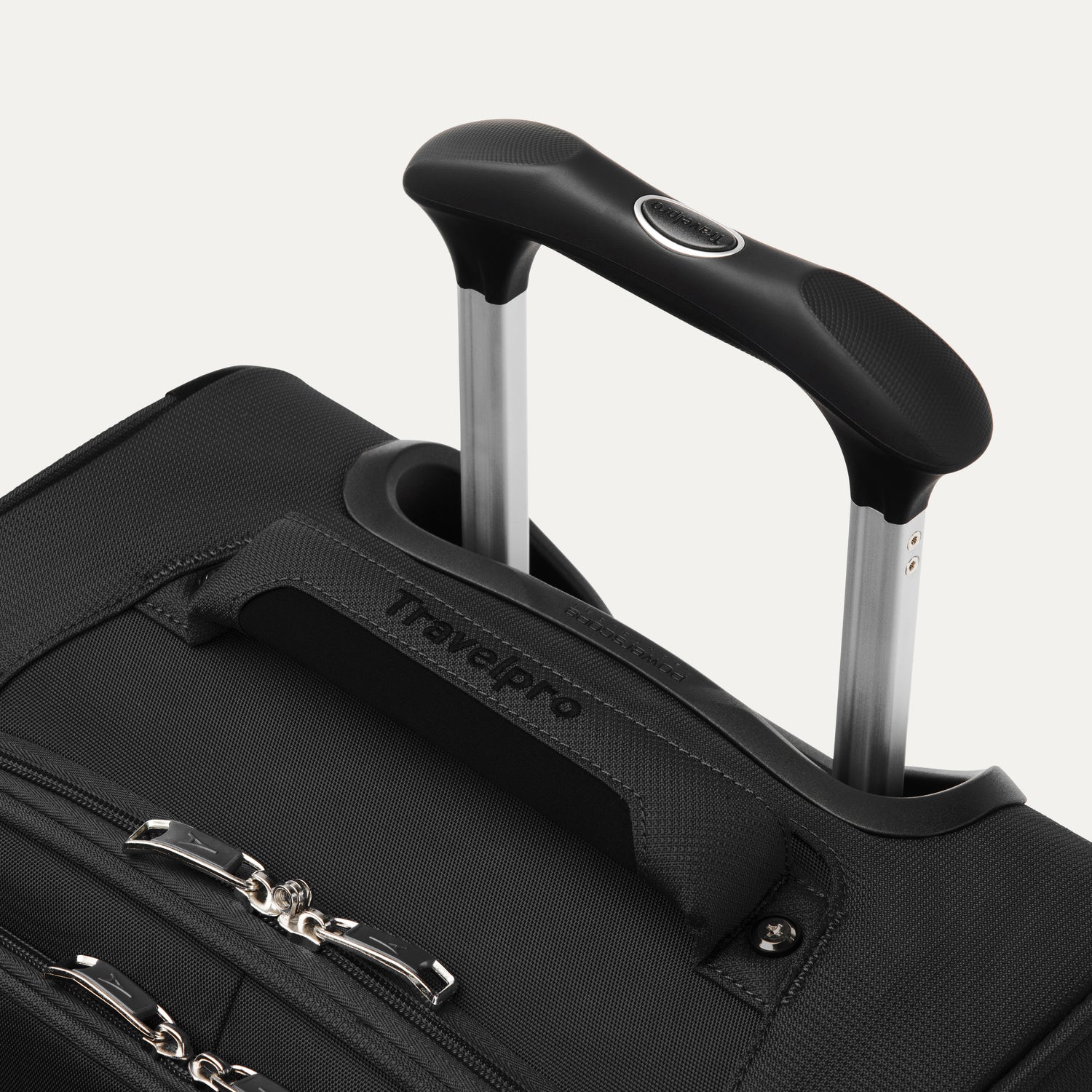 close-up view of the black travelpro maxlite® 5 carry-on spinner, showing the cushioned top carry handle with the travelpro logo and the rubberized contour grip on the powerscope lite extension handle.