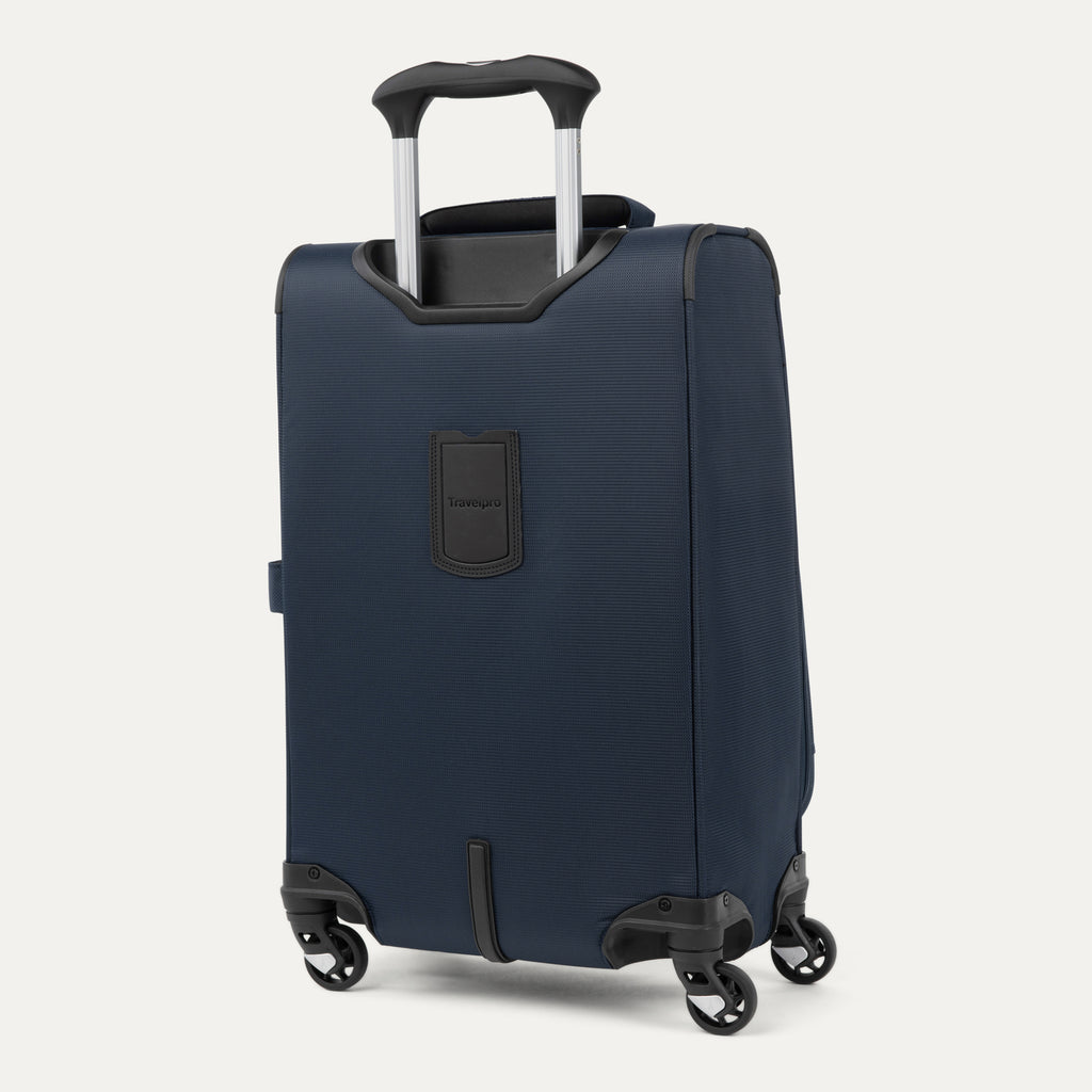 rear-angled view of the midnight blue travelpro maxlite® 5 carry-on spinner, showing the integrated trolley strap for secure stacking and the height-adjustable powerscope lite extension handle.
