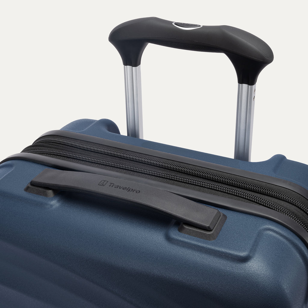 close-up view of the top of the midnight blue travelpro maxlite® air v2 hardside spinner, showing the cushioned rubberized contour grip carry handle and the adjustable powerscope lite extension handle with a push-button release.