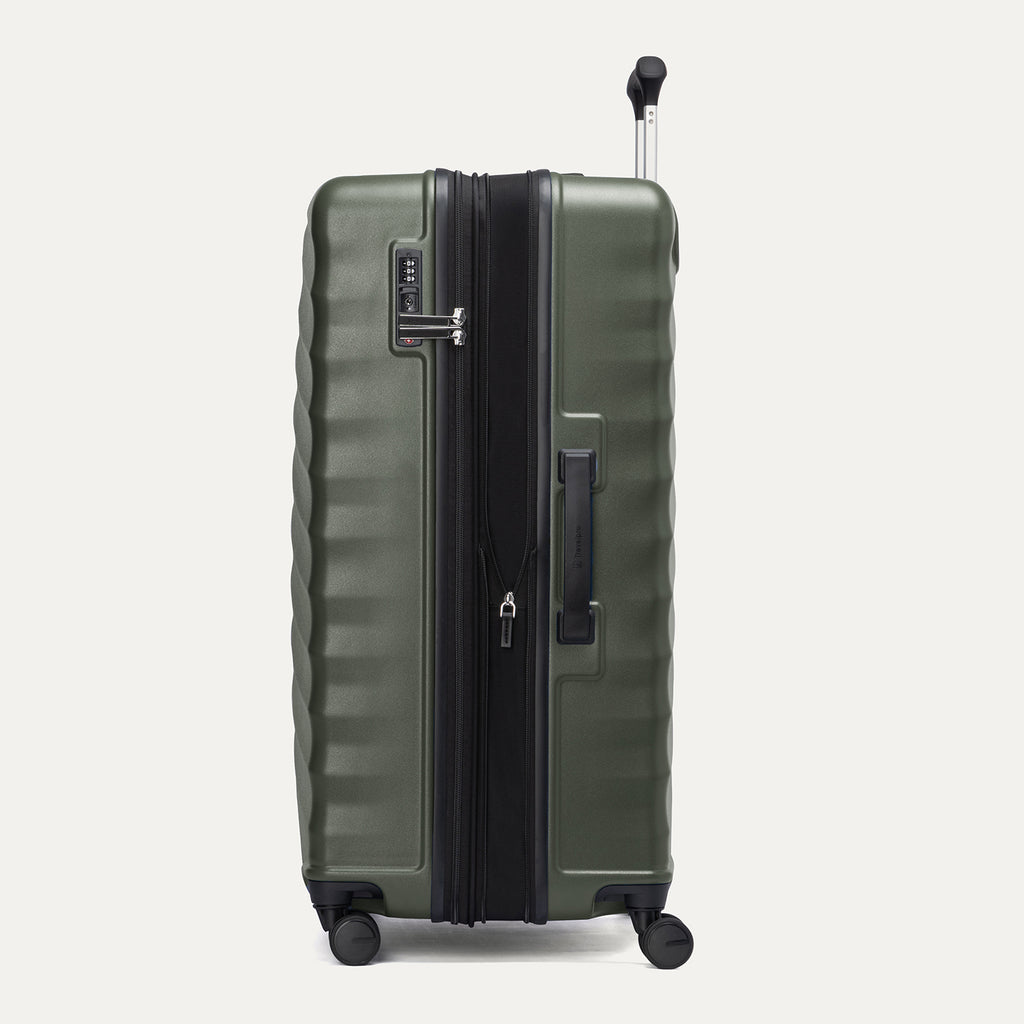 side profile view of the slate green travelpro maxlite® air v2 large check-in spinner, showing the integrated tsa-approved lock, side carry handle, and the zippered expansion feature.