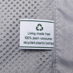 close-up view of the interior lining on the slate green travelpro maxlite® air v2 hardside luggage, showing a white fabric label that reads "lining made from 100% post-consumer recycled plastic bottles" next to the grey honeycomb-patterned fabric and mesh pocket.